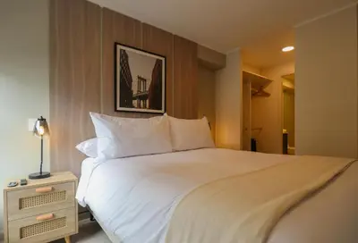 a bedroom with a large white bed and a night stand at Larco by Wynwood House in Lima