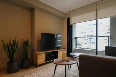 a living room with a large window and a television at Larco by Wynwood House in Lima