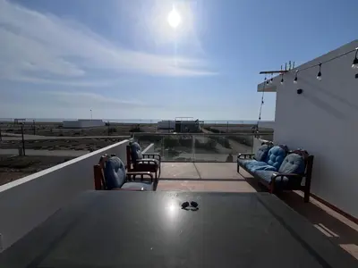 a living room with a table and chairs on a roof at Chincha CasaLed y jacuzzis sol todo el año in Tambo de Mora
