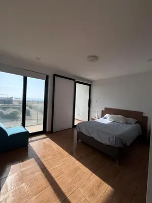 a bedroom with a bed and large glass windows at Chincha CasaLed y jacuzzis sol todo el año in Tambo de Mora