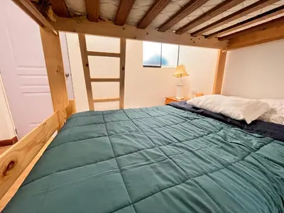 a large bed in a room with a ladder at Chincha CasaLed y jacuzzis sol todo el año in Tambo de Mora