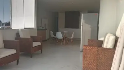a living room with chairs and a kitchen with a refrigerator at Hermoso Departamento Con Vista Al Mar in Punta Hermosa