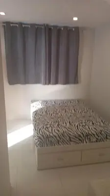 a bed in a white room with a window at Hermoso Departamento Con Vista Al Mar in Punta Hermosa