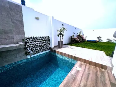 a swimming pool in the side of a house at Paradice a 30 minutos del Boulevar de Asia