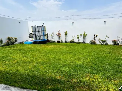 a chair sitting in the grass in a yard at Paradice a 30 minutos del Boulevar de Asia