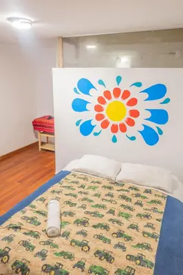 a bedroom with a bed with a flower on the wall at Room A Charming Matrimonial Room in Historic San Blas in Cusco
