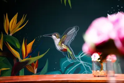 a plastic hummingbird on a wooden table with flowers at Olivar House Hotel in Lima