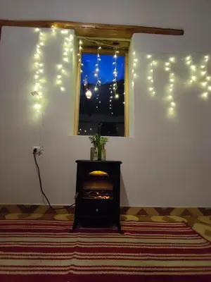 a living room with a window with christmas lights at Loft acogedor in Ollantaytambo