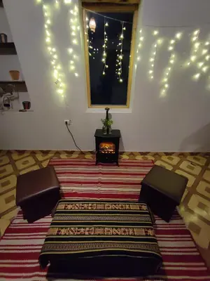 a room with a rug and a table and lights at Loft acogedor in Ollantaytambo
