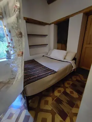 a small bed in a small room with a window at Loft acogedor in Ollantaytambo