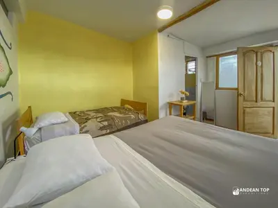 a bedroom with two beds and a refrigerator at Room E Warm and Practical Room for Families or Friends in Cusco