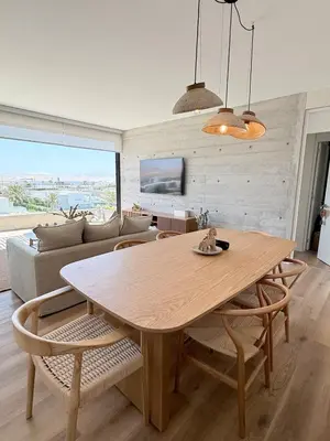 a dining room table and chairs in a living room at Paracas Navigare 2 BD Vista Reserva y Mar Último piso Terraza Kamado BBQ in Santo Domingo
