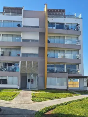 a large apartment building with a parking lot at Paracas Exclusivo Departamento familiar in Pisco