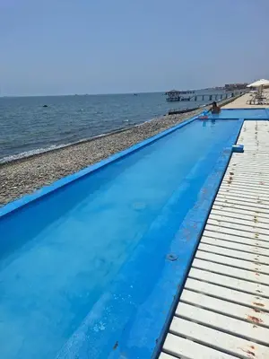 an empty swimming pool next to the ocean at Paracas Exclusivo Departamento familiar in Pisco