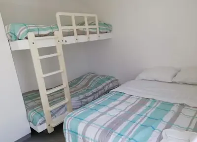 a bedroom with two bunk beds and a bed at Paracas Exclusivo Departamento familiar in Pisco