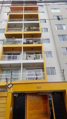 an apartment building with yellow balconies and a door at Apartamento Ideal en Zona Céntrica in Lima