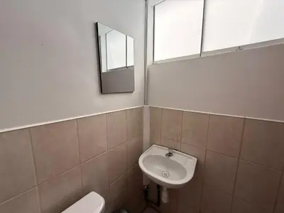 a bathroom with a sink and a toilet and a mirror at Hostal La Reserva - Pisco in Pisco