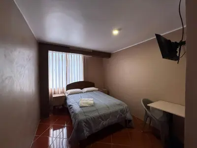 a small bedroom with a bed and a window at Hostal La Reserva - Pisco in Pisco