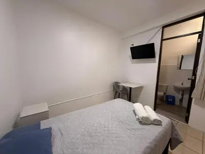 a bedroom with a bed with two towels on it at Hostal La Reserva - Pisco in Pisco