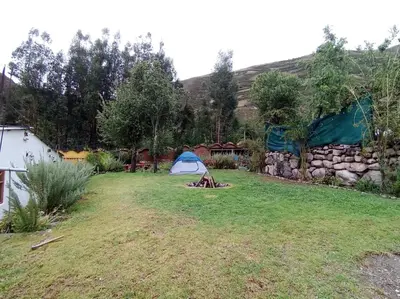 a yard with a tent and a stone wall at Huilka Mayu in Urubamba