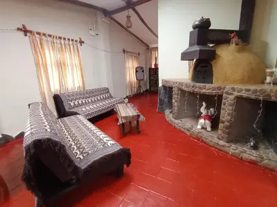 a living room with two couches and a fireplace at Huilka Mayu in Urubamba