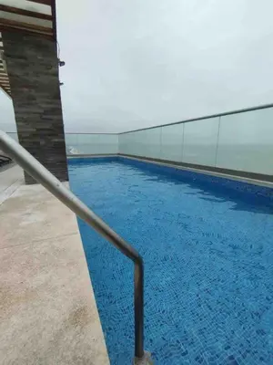 a large blue swimming pool with a metal railing at COSTANERA Uno in Lima