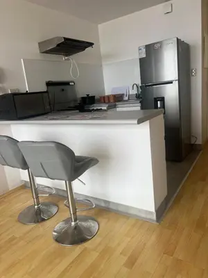 a kitchen with a counter with two bar stools and a refrigerator at COSTANERA Uno in Lima