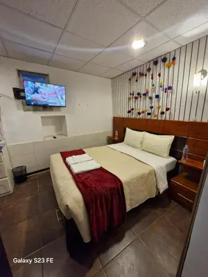 a hotel room with a bed and a flat screen tv at All sur departamento in Machu Picchu