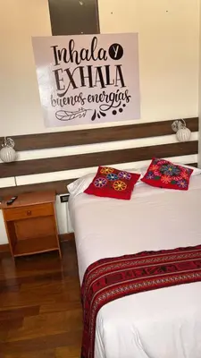 two beds in a room with a sign on the wall at All sur departamento in Machu Picchu