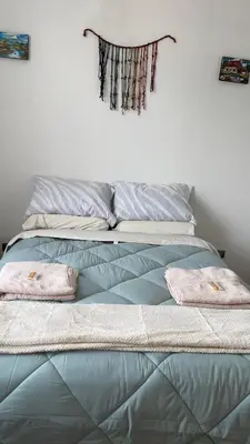 a blue bed with two pillows on top of it at Casa Departamento en el Valle de Urubamba in Urubamba