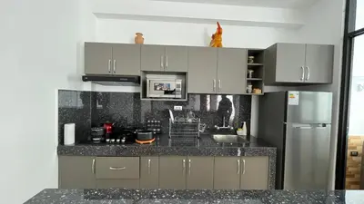 a kitchen with gray cabinets and a stainless steel refrigerator at Departamento en Urubamba in Urubamba