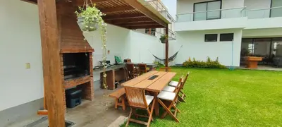 a patio with a wooden table and chairs in a yard at Casa Ribera Este in Cieneguilla