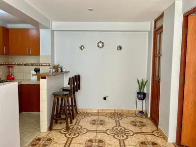 a kitchen with a counter and stools in a room at Cozy & Centric Apartment in great location! in Cusco