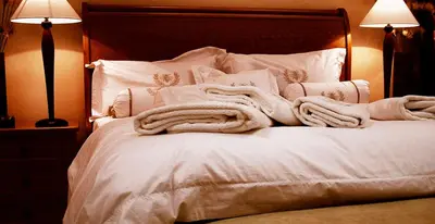 a white bed with white sheets and pillows at Hotel Bartol in Huancayo