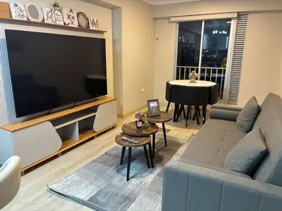 a living room with a couch and a large television at Modern apartment overlooking Parque de las Aguas in Lima