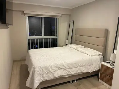 a bedroom with a large bed and a window at Modern apartment overlooking Parque de las Aguas in Lima