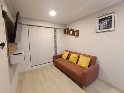 a living room with a couch with two yellow pillows at Comfortable apartment in Parque la Reserva in Lima