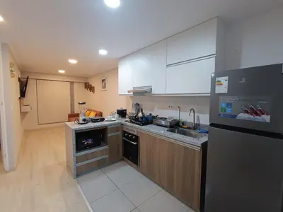 a kitchen with white cabinets and a black refrigerator at Comfortable apartment in Parque la Reserva in Lima