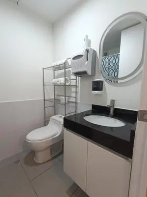 a bathroom with a toilet and a sink and a mirror at Comfortable apartment in Parque la Reserva in Lima