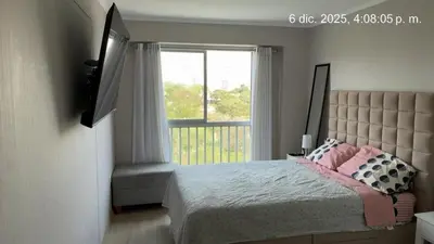 a bedroom with a bed with a large window at Cozy apartment overlooking Parque de las Aguas in Lima