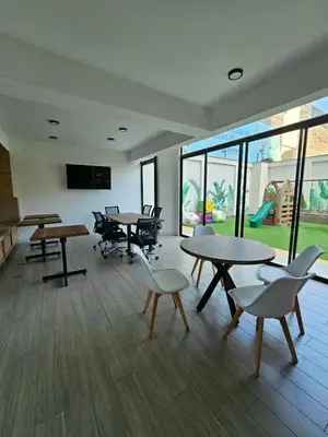 a large room with tables and chairs and windows at Apartamento Moderno in Lima