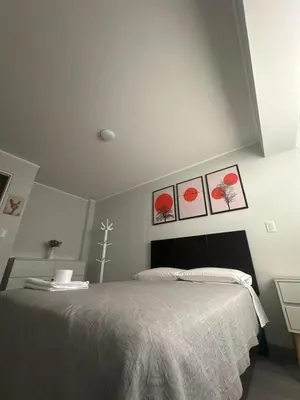 a bedroom with a bed with three pictures on the wall at Luxury Duplex on the 15th Floor with Terrace in Lima