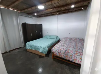 a room with two beds and a cabinet and a bed at Casa de campo El paraiso cerca a Lima in Nuevo Imperial