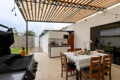 a kitchen and dining room with a table and a stove at Huaral House Piscina y Terraza in Huaral