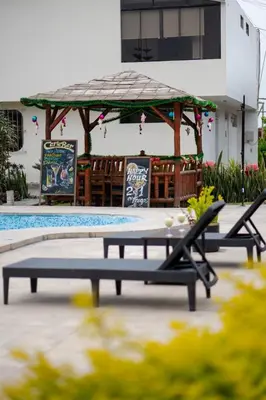a patio with two benches and a gazebo at Huaral House Piscina y Terraza in Huaral