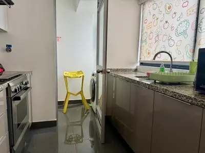 a yellow chair in a kitchen with a sink at Departamento completo vista al mar,piscina,gimnasio,WIFI,Tvs in Lima