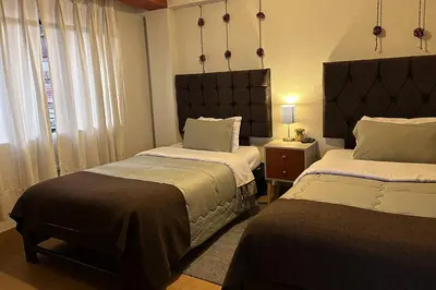 a bedroom with two beds and a window at Apartment with terrace and outdoor kitchen in Cusco