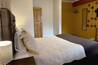 a bedroom with a large bed with white sheets at Apartment with terrace and outdoor kitchen in Cusco