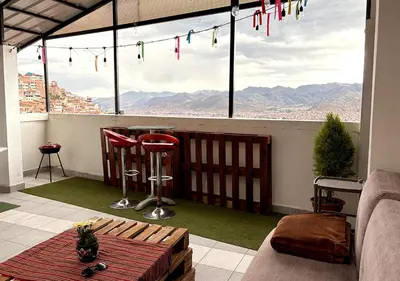 a balcony with a table and a view of the mountains at Apartment with terrace and outdoor kitchen in Cusco