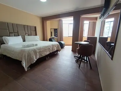 a bedroom with a bed and a table and chairs at Kapricho Wanka in Huancayo